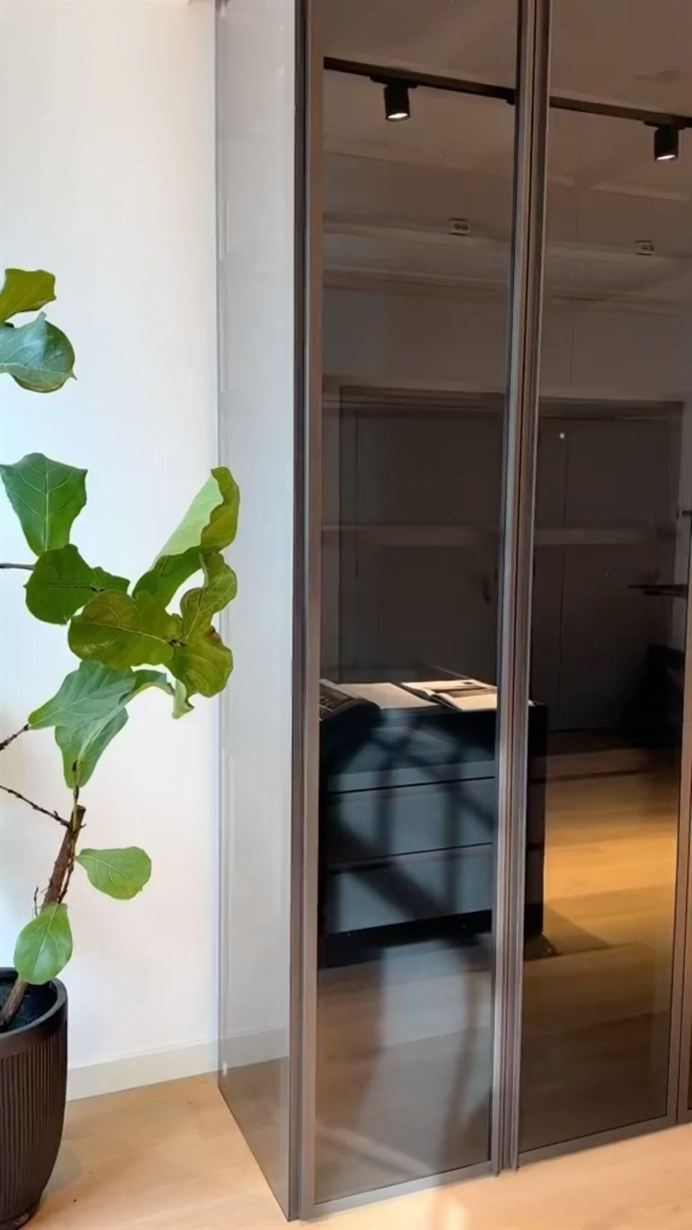 Maatwerk kast met rookglasdeuren in een lichte ruimte