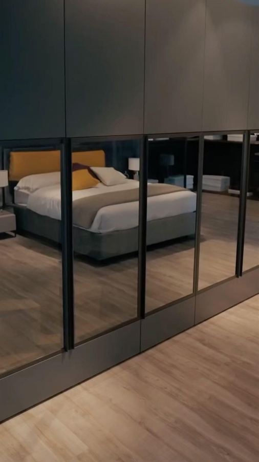 Slaapkamer met kastwand met glasdeuren in de showroom